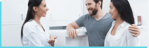 Hygienist talking with a smiling young couple